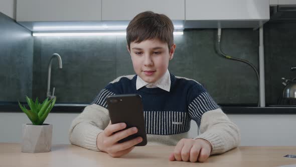 Portrait of Handsome Boy of 13 Ages Using Smartphone at Home