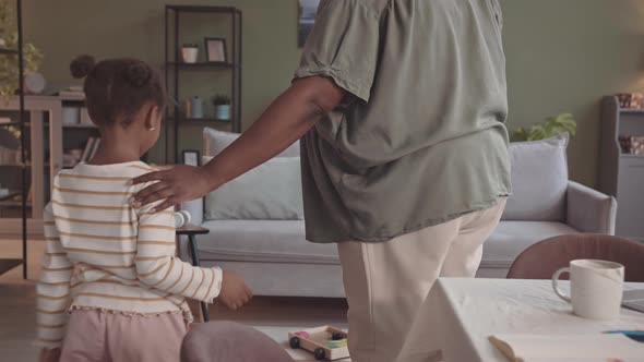 African-American Mother and Little Daughter Relaxing on Sofa at Home