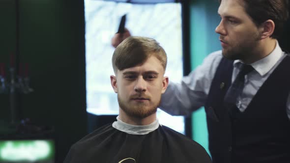 Handsome Young Man Getting a Haircut at the Barbershop