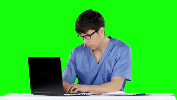 Young Male Doctor Working on Laptop. Green Screen