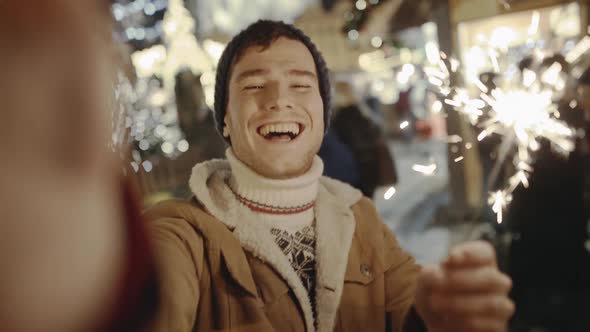 Funny Young Man Smiling and Making Selfie with His Smartphone at Amazing Street Fair in Old European