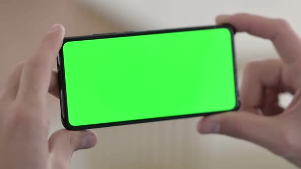 Holding Horizontal Smartphone with Green Chroma Screen 