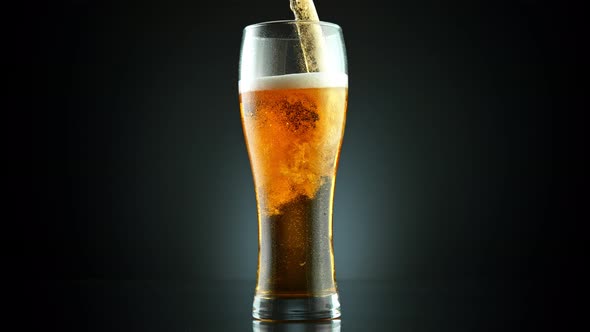 Super Slow Motion Shot of Pouring Fresh Beer Into Glass on Black Background at 1000Fps.