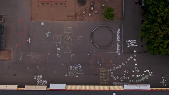 Crayon drawings on school sidewalk in aerial drone view