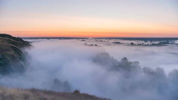 Timelapse Mist Curling Over River and Meadow on Sunrise Background