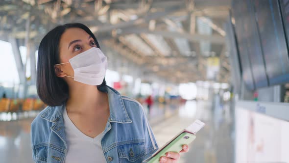 Woman passenger wearing face mask walking in airport terminal to boarding gate during the COVID.