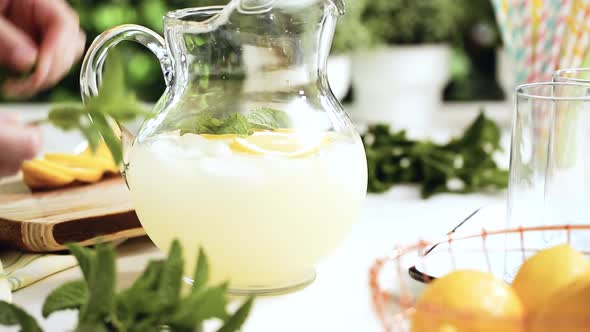 Step by step. Preparing traditional lemonade with fresh sliced lemons and mint.