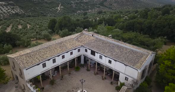 Aerial view of a traditional spanish cottage surrounded by olives.