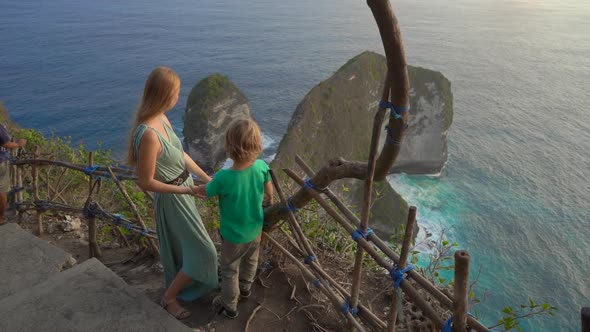 Young Woman and Her Little Son Tourists Visit the So-called Tyrannosaur Rock at the Kelingking Beach