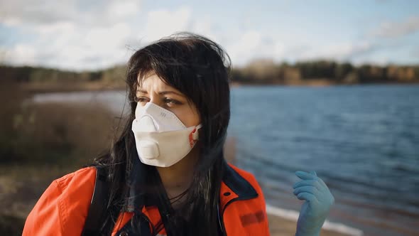 Serious Female Paramedic Turns Head and Looks at you Near Blue Lake