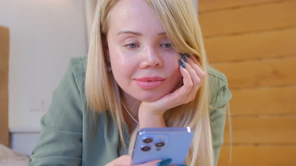 Domestic abuse victim with prosthetic eye and facial scars using modern mobile phone