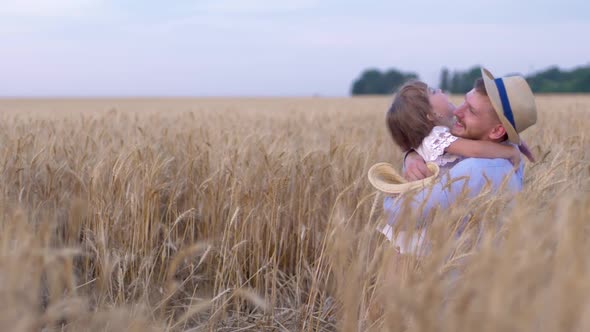 Happy Meeting, Little Cute Girl Hugging Happy Man on Wheat Field During the Harvest Season Against