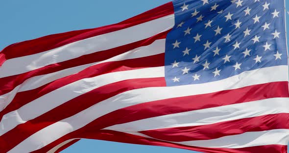 American flag waving in the wind on blue sky