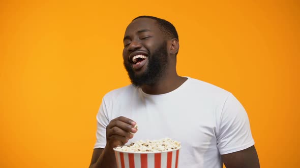 Cheerful Afro-American Man Eating Popcorn and Laughing Out Loud, Comedy Show