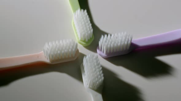 Four Toothbrushes Lying on Table and Spinning
