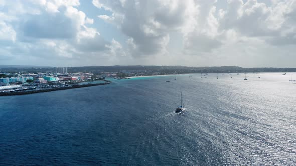 Drone camera approaches a yacht sailing in the sea near Bridgetown, Barbados