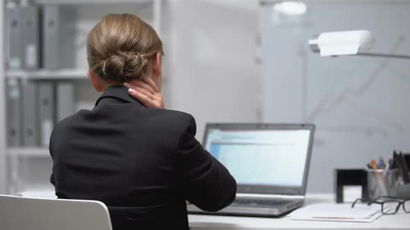 Tired Woman Massaging Numb Neck Working Laptop, Pinched Nerve, Back View