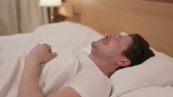 Middle Aged Man Crying while Sleeping in Bed