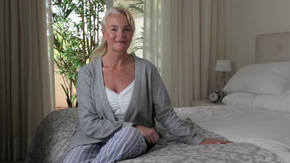 Mature woman sitting on bed