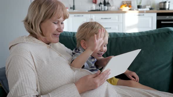 Mother And Baby Child Communicate Together To Video Link With Dad And Relatives