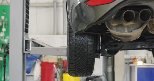 A Car Goes Up On The Lift In The Auto Repair Shop. Close Up