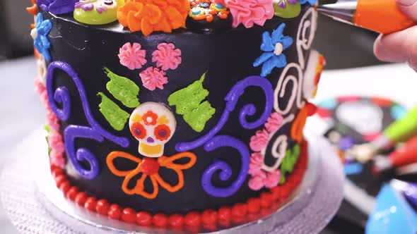 Step by step. Baker decorating multilayer chocolate cake with colorful italian buttercream frosting.