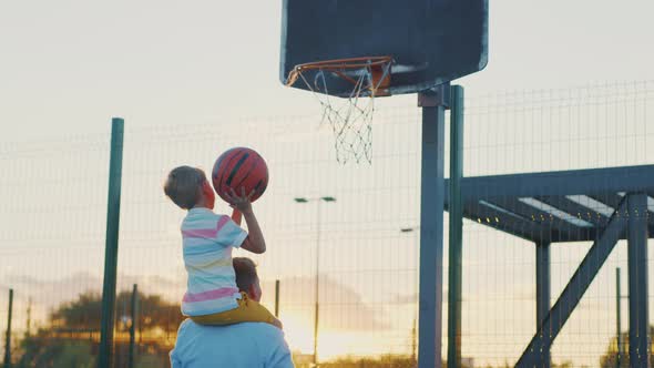 Young family playing basketball on the court