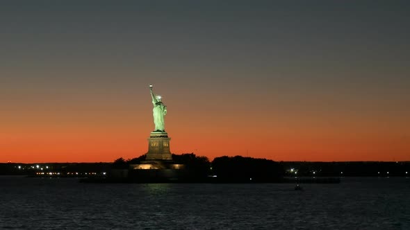 wide angle view of a sunset and the statue of liberty