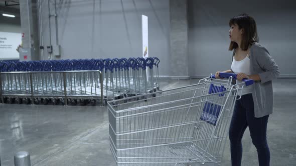 Young Asian woman using elevator in warehouse hoosing new furniture in department store.