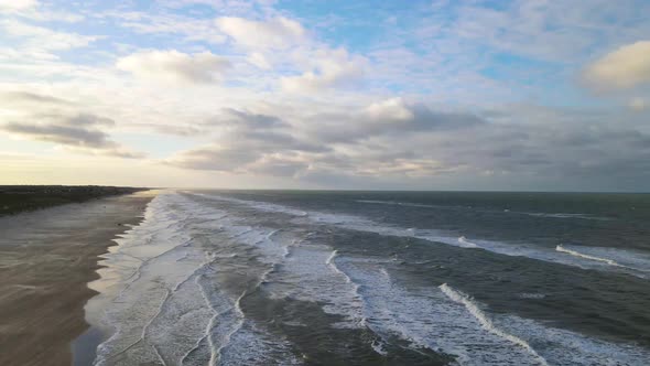 Aerial view of rolling waves and sunrise at the ocean close to Løkken by the North Sea, Denmark