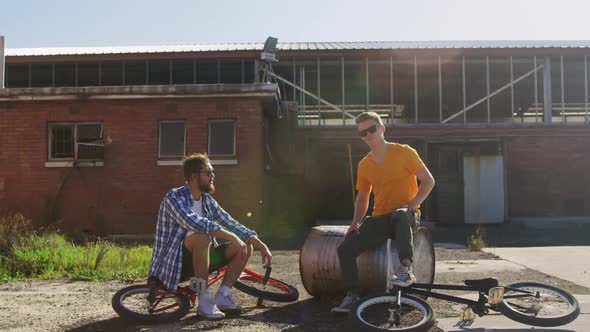 BMX riders sitting in a yard talking