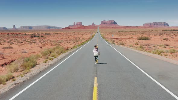 Cinematic Aerial Athletic Woman Running By Highway to Monument Valley Nature