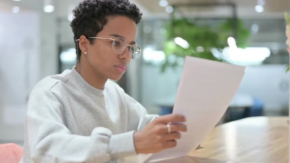 Casual African Woman Reading Documents