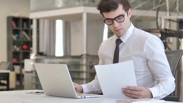 Businessman Reading Documents in Office