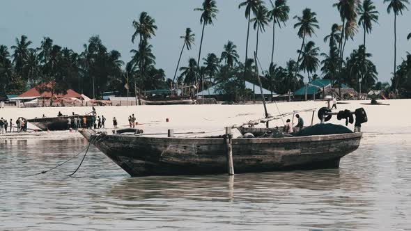 African Traditional Wooden Boat Stranded in Sand on Beach at Low Tide Zanzibar