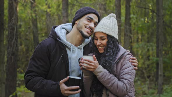 Young Couple in Love Stand in Embrace in Nature Drinking Tea Communicate Enjoy Romantic Date Happy