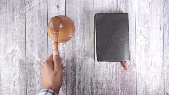 Top View of Person's Hand Striking the Gavel