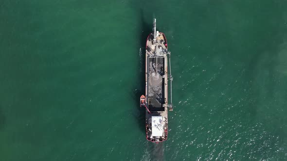 A large industrial dredging vessel sits in a shipping channel pumping tons of sand for a city rejuve