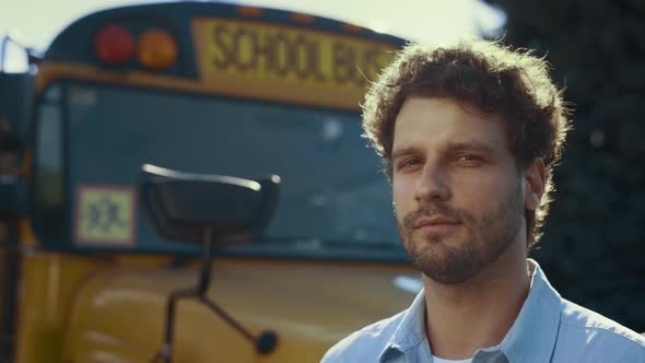 Confident Man Driver Stand at Yellow Bus Looking Camera in Sunlight Close Up