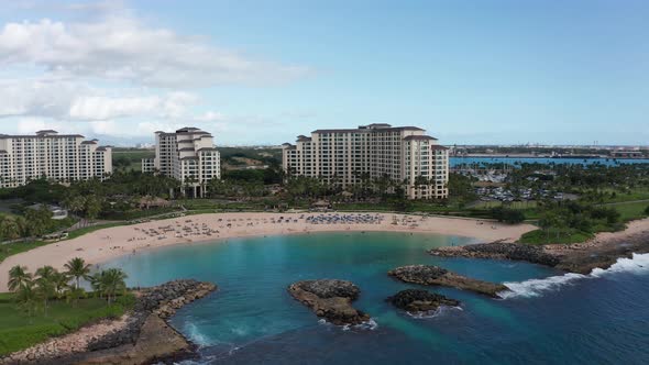 Panning aerial shot of a luxury resort along a coastal lagoon in Ko'Olina, Hawaii. 4K