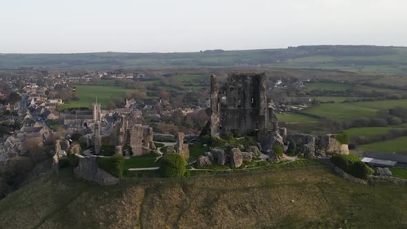 Corfe Castle ruins and beautiful landscape in background, County Dorset in United Kingdom. Aerial ap