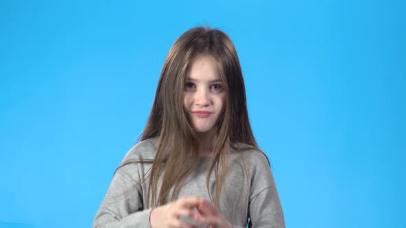 Blonde Teenage Clapping Her Hands, Smiling, Looking at the Camera.