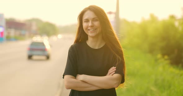 Confident Charming Attractive Woman with Her Arms Crossed on Her Chest in Casual Clothes Poses for