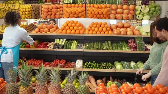 Multiracial Couple Choosing Vegetables in Store