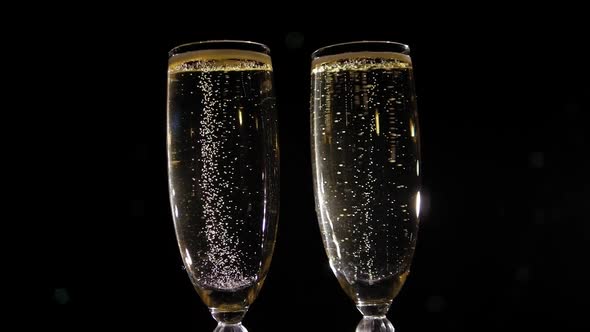 Closeup of Two Glasses of Champagne with Bubbles on a Black Background