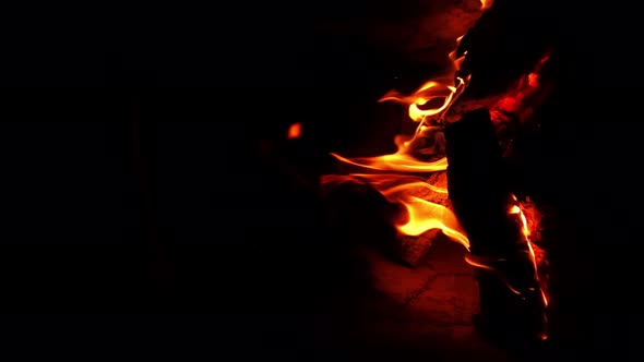 Vertical Footage of Burning Fireplace in the Darkness with Vibrant Tongues of Flames