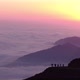 Tourist Silhouettes on Hill Top Against Foggy Mountains - VideoHive Item for Sale