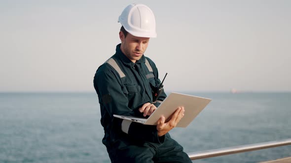 Concentrated Port Inspector Supervisor Working on Laptop Computer in Ship Terminal