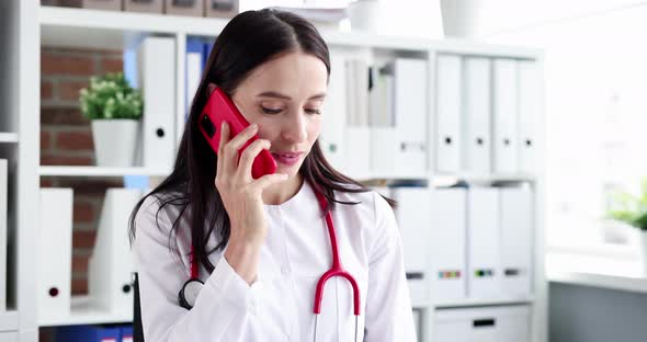 Woman Doctor Consults Patient on Phone at Workplace