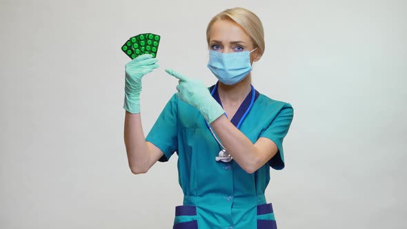 Medical Doctor Nurse Woman Wearing Protective Mask and Rubber or Latex Gloves - Holding Pills